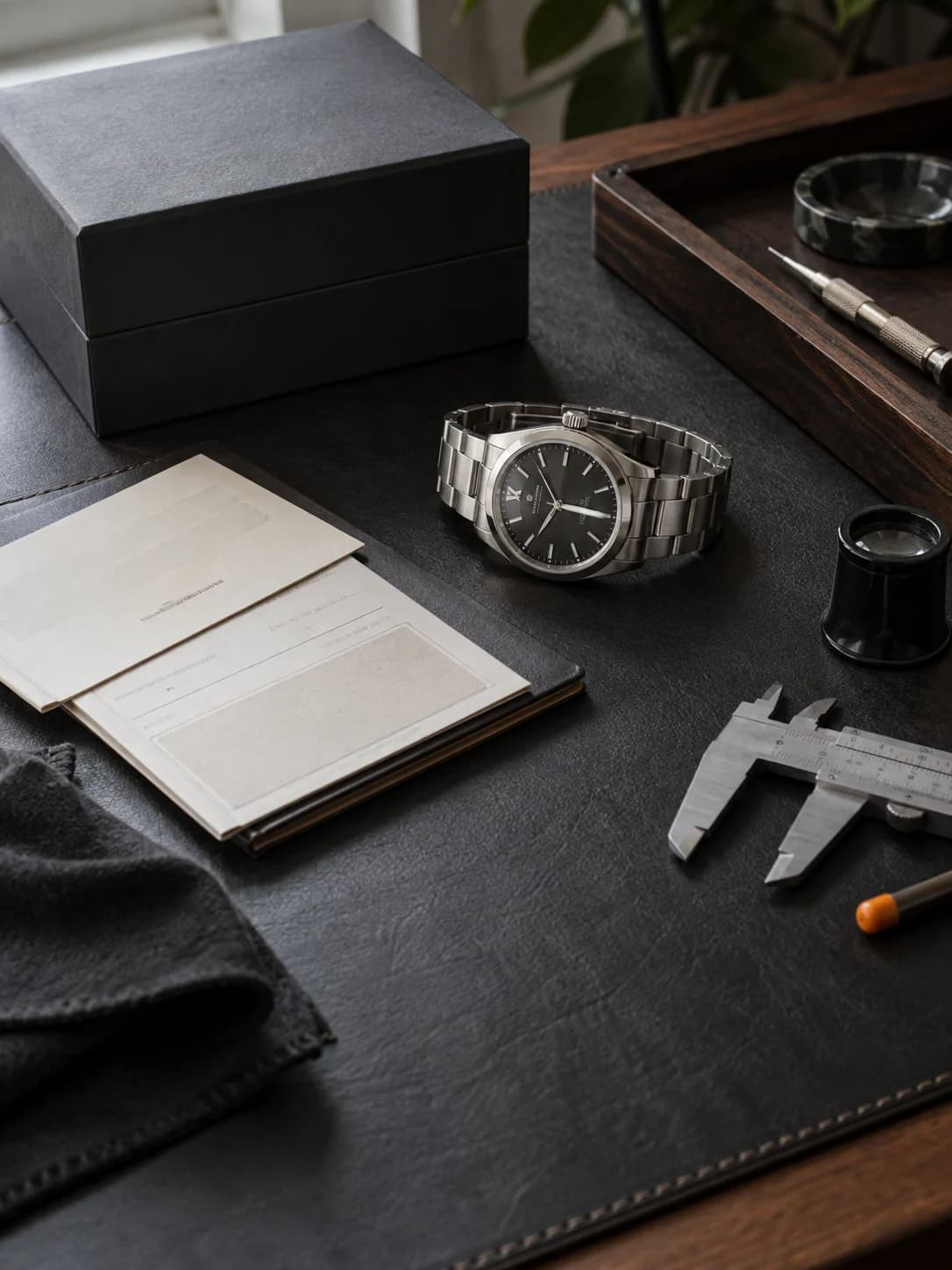A watch and its papers on the bench, ready for valuation